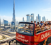 Dubai city tour bus package sightseeing bus near Burj Khalifa with tourists exploring Dubai landmarks