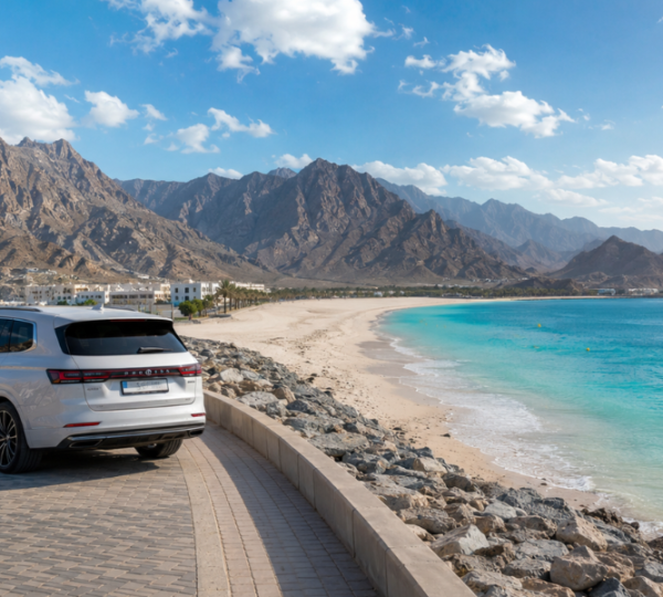 Khor Fakkan Tour From Abu Dhabi - Scenic East Coast Mountain & Beach Escape Scenic coastal views of Khor Fakkan beach with Hajar Mountains backdrop on a full day tour from Abu Dhabi