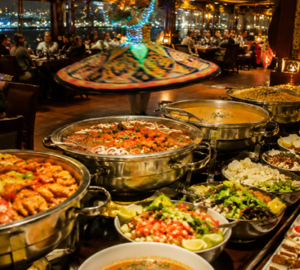 Dubai Creek Dhow Cruise Buffet Dinner and Tanoura Entertainment International buffet dinner spread and Tanoura dance performance on Dubai Creek dhow cruise