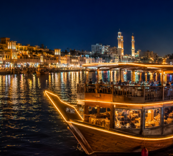Dubai Creek Dhow Cruise Night Experience with Illuminated Heritage Buildings Traditional dhow cruise at night on Dubai Creek with illuminated heritage buildings and Old Dubai skyline