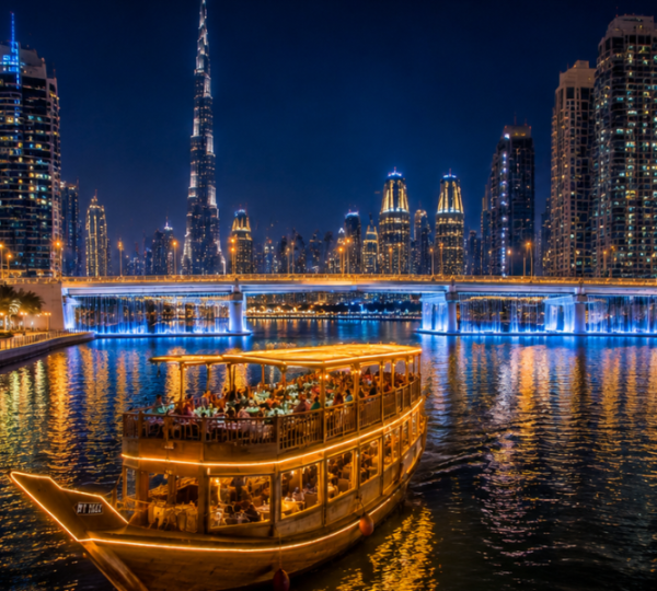 Traditional wooden dhow sailing on Dubai Water Canal with illuminated Business Bay skyline and Burj Khalifa at night