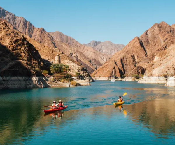 Spectacular Hatta Dam with turquoise reservoir surrounded by Hajar Mountains, kayaking activity on calm waters