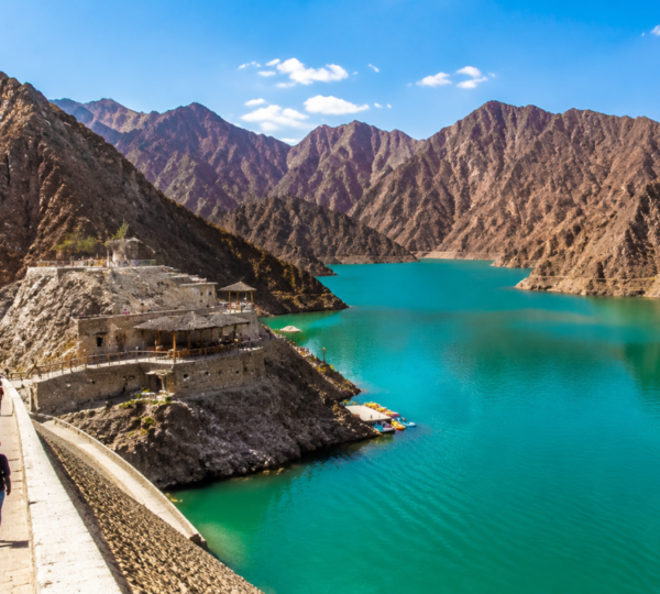 Hatta Dam with turquoise blue water surrounded by rugged Hajar Mountains, a popular photo stop on Hatta Hill Park tour