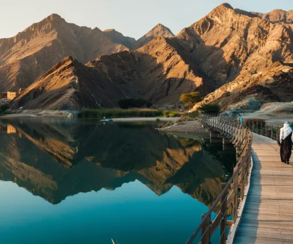 Stunning Hatta Swan Lake Bridge suspension bridge over turquoise lake surrounded by Hajar Mountains on a guided tour from Dubai
