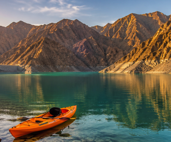Khor Fakkan Tour With Kayaking โ Al Rafisah Dam Kayaking at Al Rafisah Dam with Hajar Mountains reflecting in calm turquoise water