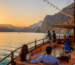 Musandam overnight dhow cruise from Dubai sailing through Khasab fjords at sunset