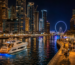 Things to do in Dubai Marina at night with illuminated skyline and luxury yacht