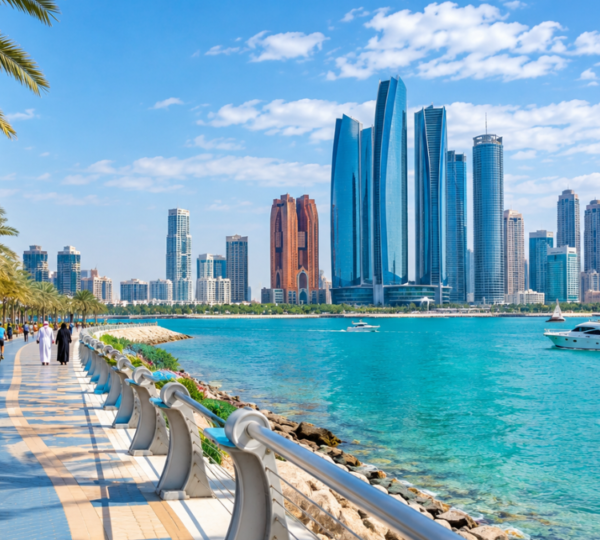 Abu Dhabi Corniche Waterfront – City Tour Photo Stop | Zutours Abu Dhabi Corniche waterfront with modern skyline, palm trees, and turquoise Arabian Gulf waters on a sunny day